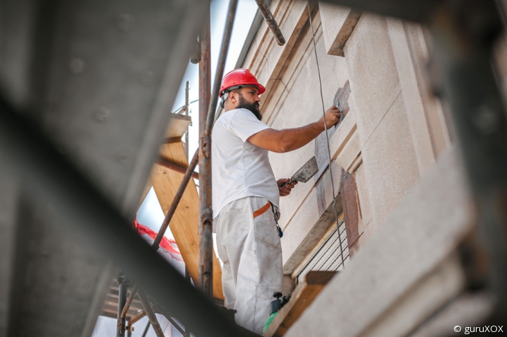 Artisan du bâtiment travaillant sur une façade