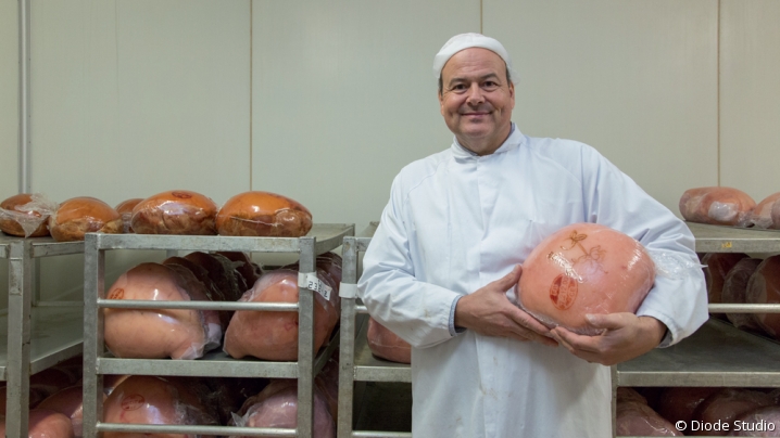 Jean-François Antoine pose avec un de ses jambons dans un atelier de la Charcuterie Bentz