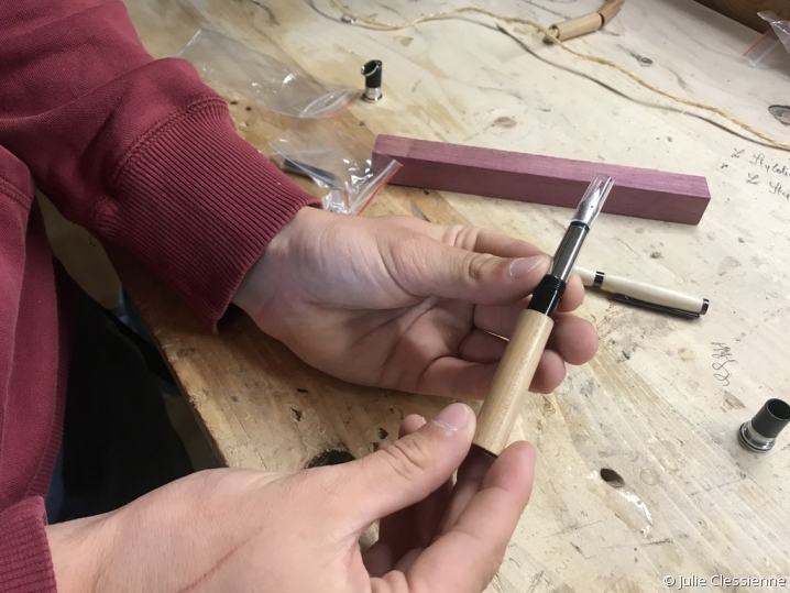 Le stylotier tient le produit fini : un stylo en bois tourné 