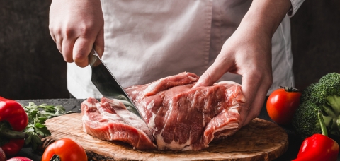 Artisan boucher tranchant un bifteck