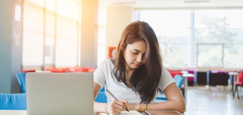 Jeune fille révisant ses cours grâce à une tablette numérique