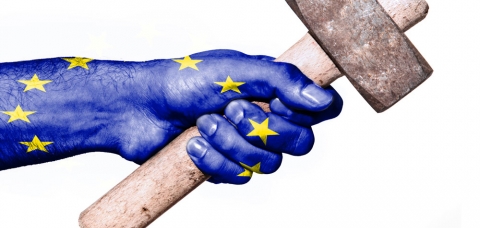 Drapeau européen en filigrane d'une main tenant un marteau